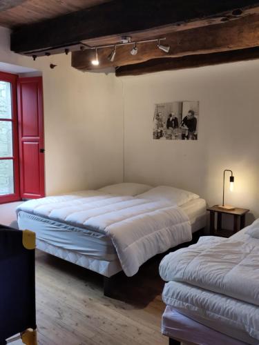 a bedroom with two beds and a red window at Maison familiale, 15couchages, de charme au cœur de la Bretagne - 20 min de Vannes in Lizio