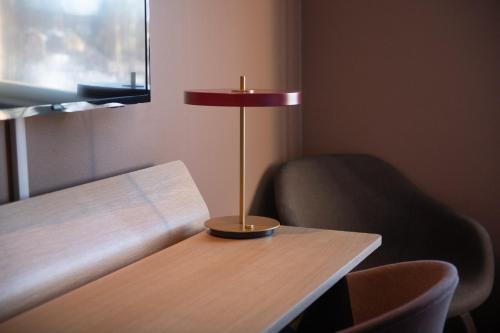 a lamp sitting on a table next to a chair at Medlefors Hotell & Konferens in Skellefteå