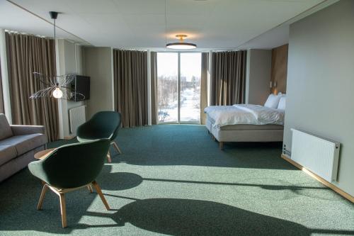 a hotel room with a bed and a couch and a television at Medlefors Hotell & Konferens in Skellefteå