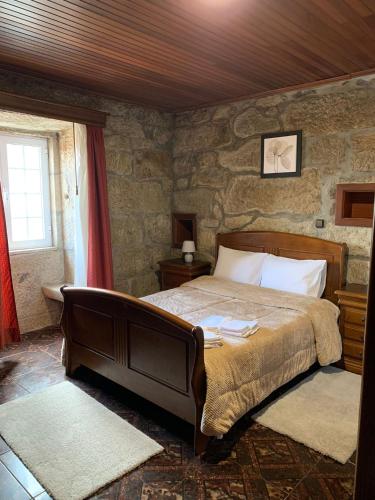 um quarto com uma cama e uma parede de pedra em Cobal 's HOUSE em Viseu