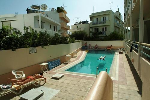 a swimming pool with two people in a building at Theonia Hotel in Kos Town