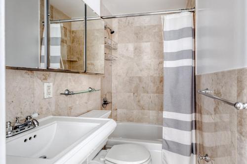 a bathroom with a tub and a toilet and a sink at Hip E Village 2BR w WD nr L Train NYC-824 in New York