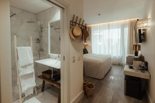 a bathroom with a bed and a sink and a mirror at AlmaLusa Comporta in Comporta