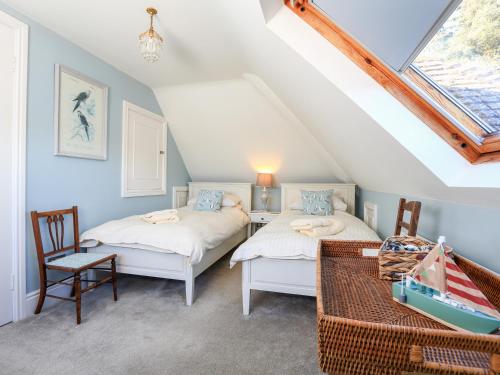 two beds in a attic room with a window at 2 Channel View in Salcombe
