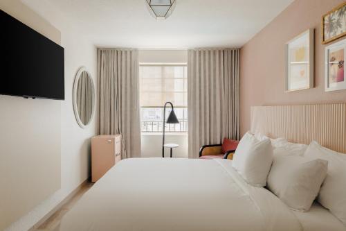 a hotel room with a large white bed and a window at Found Miami Beach powered by Sonder in Miami Beach