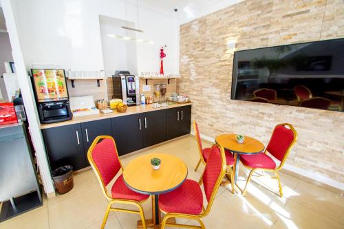 un restaurante con 2 mesas y sillas y una cocina en Hôtel Parisien, en Niza