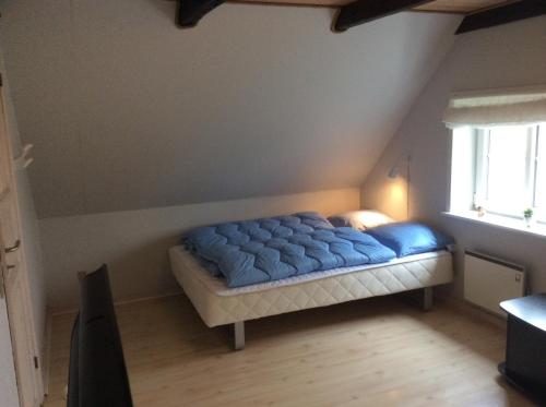 a bedroom with a blue bed in a attic at Axelgaard Guest Rooms in Ovtrup