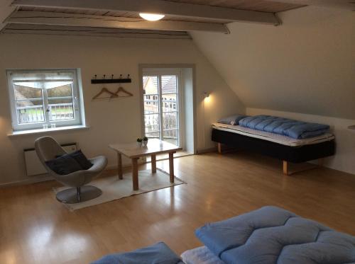 Axelgaard Guest Rooms في Ovtrup: غرفة بسرير وكرسي وطاولة