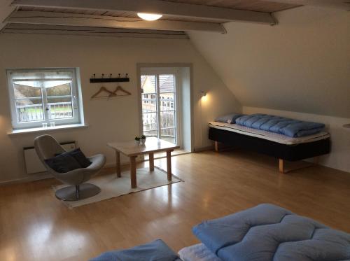 a room with a bed and a chair and a table at Axelgaard Guest Rooms in Ovtrup