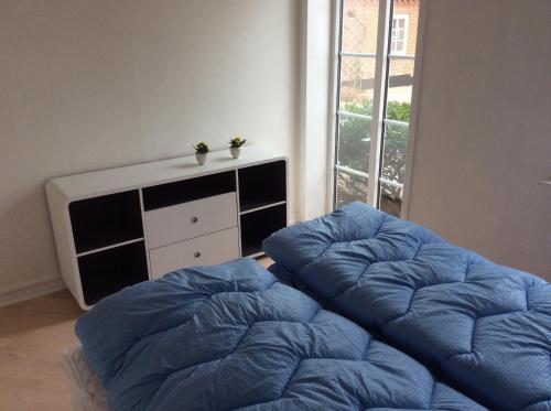 a bedroom with a large blue bed and a window at Axelgaard Guest Rooms in Ovtrup