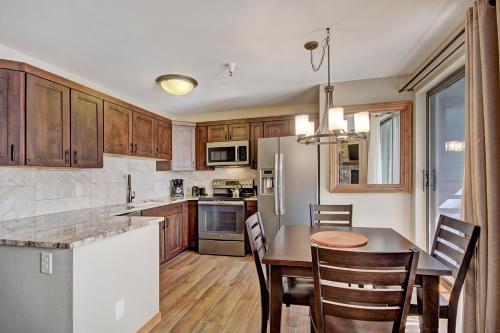 a kitchen with wooden cabinets and a table and chairs at Studio Apartment in Breckenridge