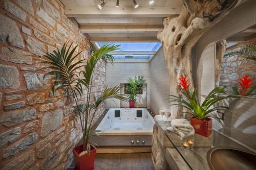 łazienka z wanną w kamiennej ścianie w obiekcie Iakovakis Suites & Spa w mieście Koropi