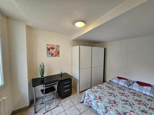 ein Schlafzimmer mit einem Bett und einem Schreibtisch. in der Unterkunft Charmant 2 pièces centre Sospel in Sospel