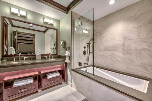 een badkamer met een bad, een wastafel en een spiegel bij Summer Sale- 2 Bedroom At Constellation Residences Condo in Kingswood Estates