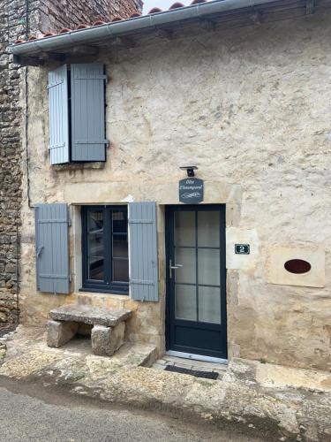 a building with a door and a bench in front of it at GITE L’INTEMPOREL in Saint-Gaudens
