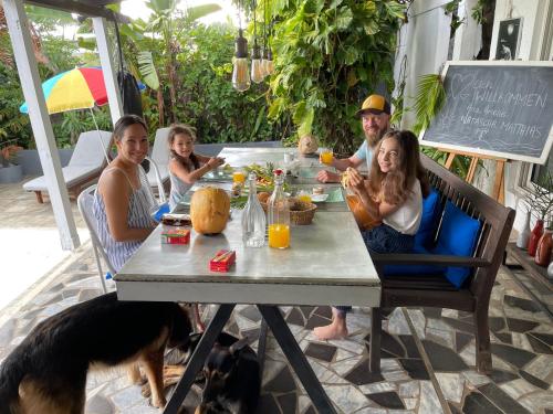 a group of people sitting at a table with a dog at Bellevue Tamarin in Tamarin