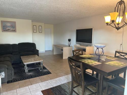 uma sala de estar com uma mesa de jantar e uma televisão em THE FLORIDIAN INN em Clearwater