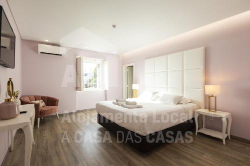 um quarto branco com uma cama e uma secretária em VIlla São Lourenço by AcasaDasCasas em Ericeira