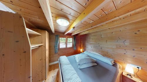 um quarto com uma cama num chalé de madeira em Ferienblockhaus 1 em Löwenstein