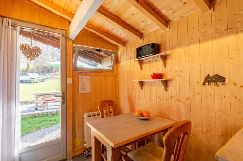 d'une salle à manger en bois avec une table et une fenêtre. dans l'établissement Sauvage, à Les Combes
