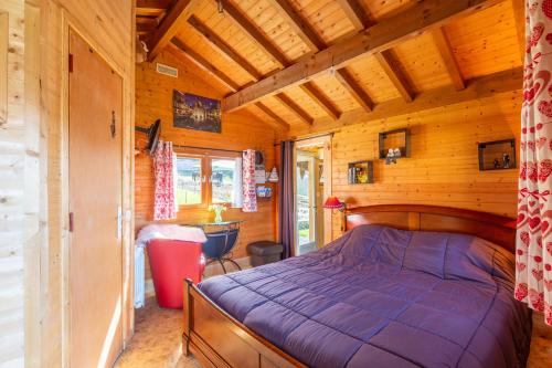1 dormitorio con 1 cama en una cabaña de madera en Sauvage, en Les Combes