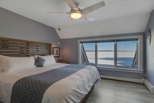 a bedroom with a bed with a ceiling fan and a window at 314 Water Street Inn in Boyne City
