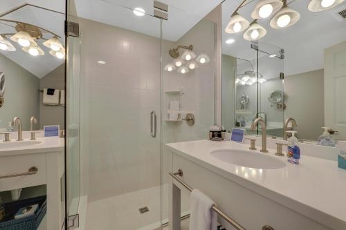 een badkamer met een glazen douche en een wastafel bij 314 Water Street Inn in Boyne City