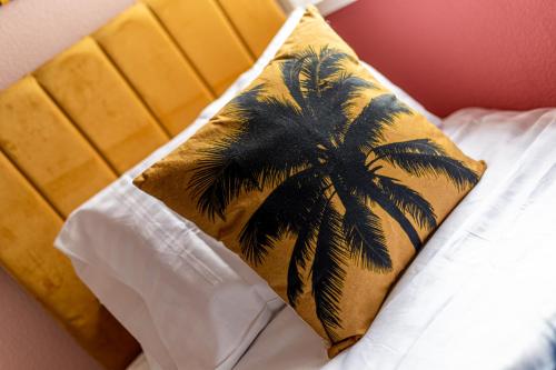 a pillow with a palm tree on top of a bed at Charles Alexander Short Stay - Botanical House in Cleveleys