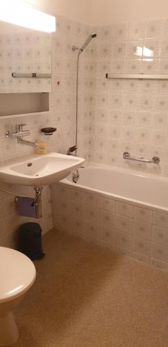 a bathroom with a sink and a tub and a toilet at Ferienwohnungen Chesa Clois 24 in Lenzerheide
