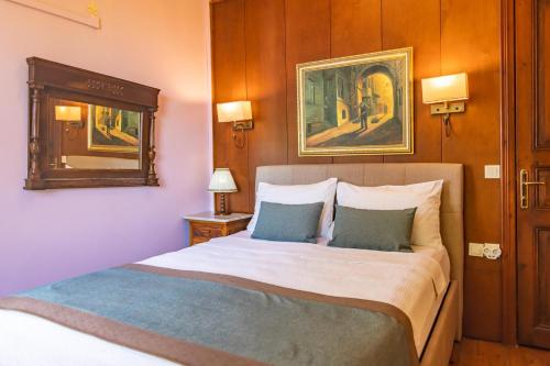 a bedroom with a large bed with two pillows at Büyükada Anastasia Meziki History Mansion in Buyukada