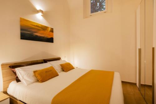 a bedroom with a bed with white sheets and orange pillows at Mirasole House in Massa Lubrense