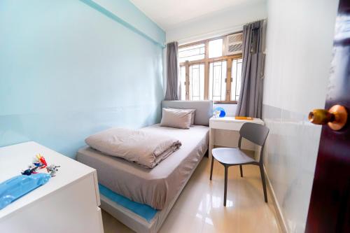 CoLiving Space - Hennessy Road 113 Wan Chai MTR في هونغ كونغ: غرفة نوم صغيرة مع سرير صغير وكرسي