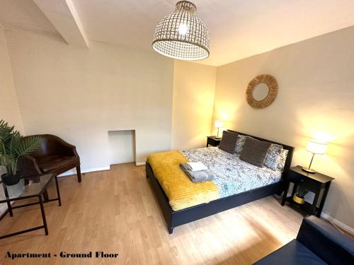 a bedroom with a bed and a chair and a lamp at Charming Flats with Fast WIFI on the Famous Abbey Road in London