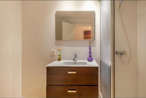 a bathroom with a sink and a mirror at Seafront Marina 1 Apartment in Pollença