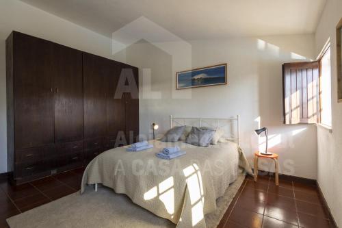 リバマルにあるVilla Coxos by AcasaDasCasasのベッドルーム1室(ベッド1台、テーブル、窓付)