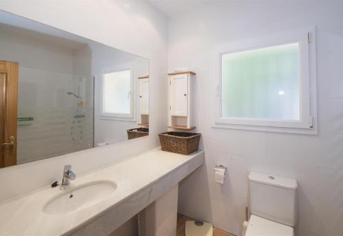 ein Badezimmer mit einem Waschbecken, einem Spiegel und einem WC in der Unterkunft Flor Begur in Begur
