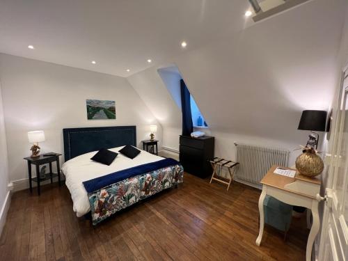 a bedroom with a bed and a table and a desk at LE PRIEURE DE BUFFON in Buffon