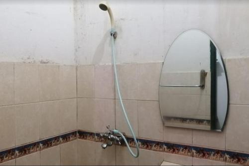 - Baño con ducha y espejo en OYO 2452 Hotel Metro en Bandung