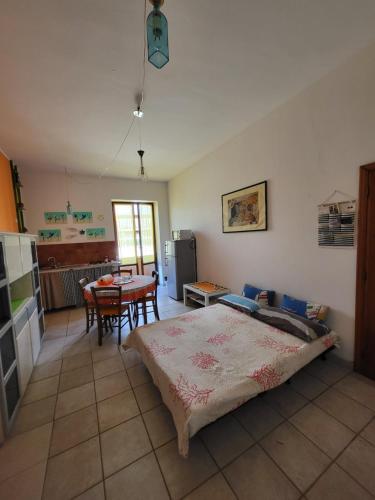 una camera con letto e una cucina con tavolo di La Palma appartamenti a Piombino