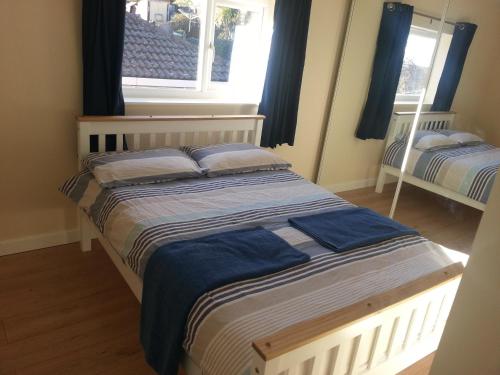 een slaapkamer met 2 bedden en een raam bij Immaculate 3-Bed House in Bristol in Bristol