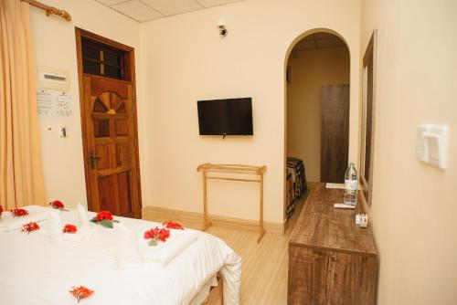 a hotel room with a bed and a tv at Summer Vibes Beach Front in Rasdu