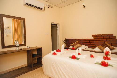 a bedroom with a bed with red flowers on it at Summer Vibes Beach Front in Rasdu