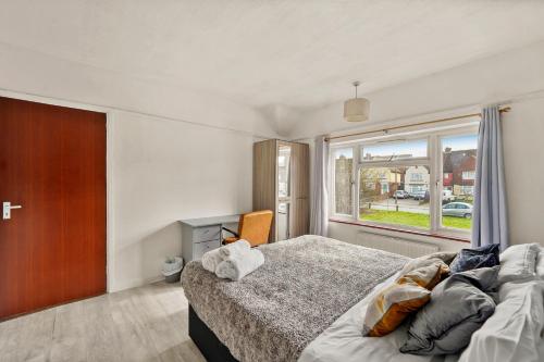 um quarto com uma cama grande e uma janela em Large House with Parking and Garden - Sleeps 7 em Kent