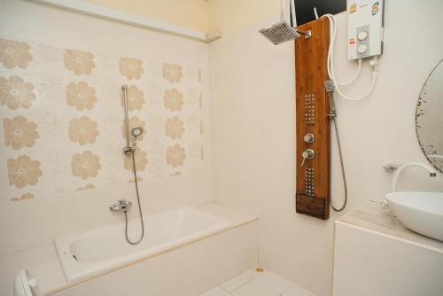 a bathroom with a shower and a tub and a sink at Summer Vibes Beach Front in Rasdu