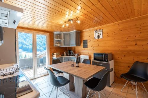 a kitchen with a table and chairs in a cabin at Au Chalet Le Péry, vue sur le Mont de Grange in Abondance