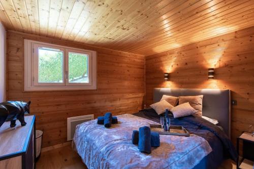 ein Schlafzimmer mit einem Bett in einer Holzhütte in der Unterkunft Au Chalet Le Péry, vue sur le Mont de Grange in Abondance