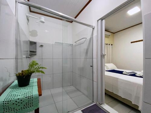 a small bathroom with a shower and a bed at Pousada Alterosa in Alter do Chao