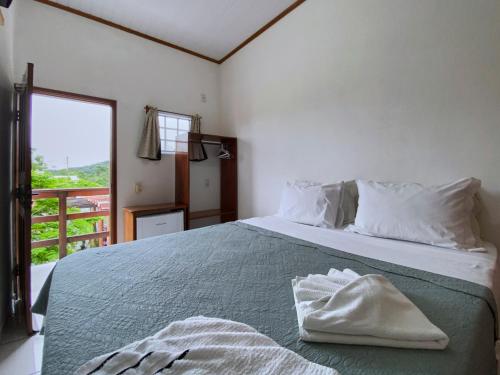 een slaapkamer met een bed met twee handdoeken erop bij Pousada Alterosa in Alter do Chao