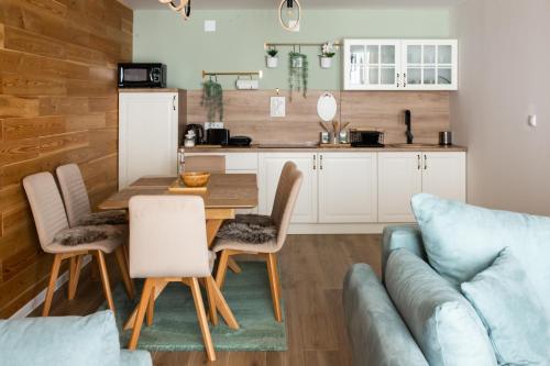 a kitchen and dining room with a table and chairs at Tarvil Apartmani - Zaovine in Bajina Bašta