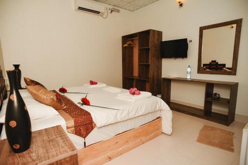 a bedroom with a bed with flowers on it at Summer Vibes Beach Front in Rasdu